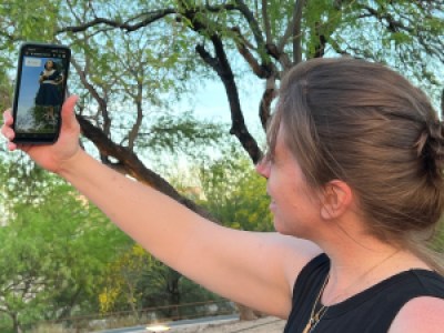 Laura Caywood Barker enjoys interacting with a hologram at Bonita Park on the Borderlands Theater pathway, photograph by Lisa Falk, ASM.